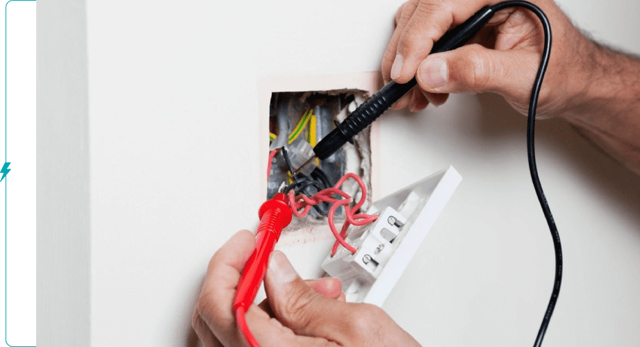 A person is cutting the wires in an electrical box.